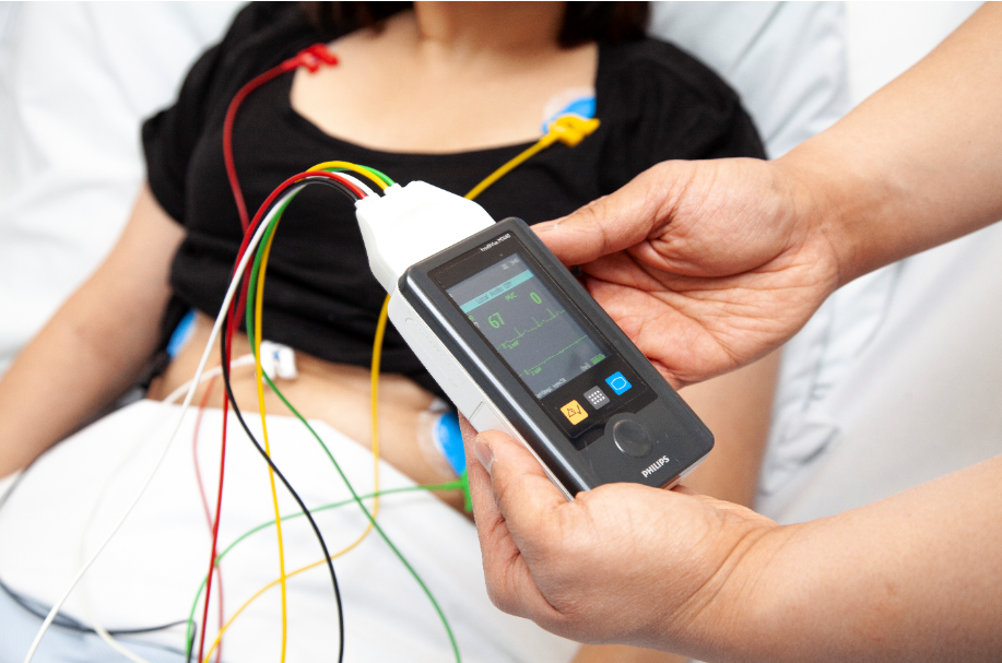 Close up of hand-held machine attached to a patient by 4 differently coloured wires